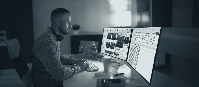 A control room operator reviewing videos on multiple monitors
