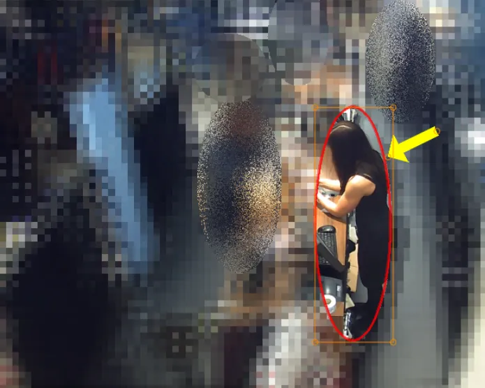 CCTV still with the whole background heavily blurred, leaving only one person, circled in red and marked with an arrow, in focus.